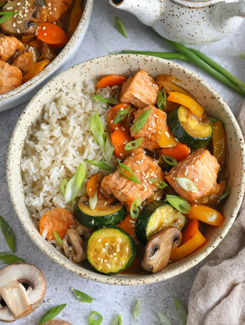 A bowl of rice and meat with vegetables.