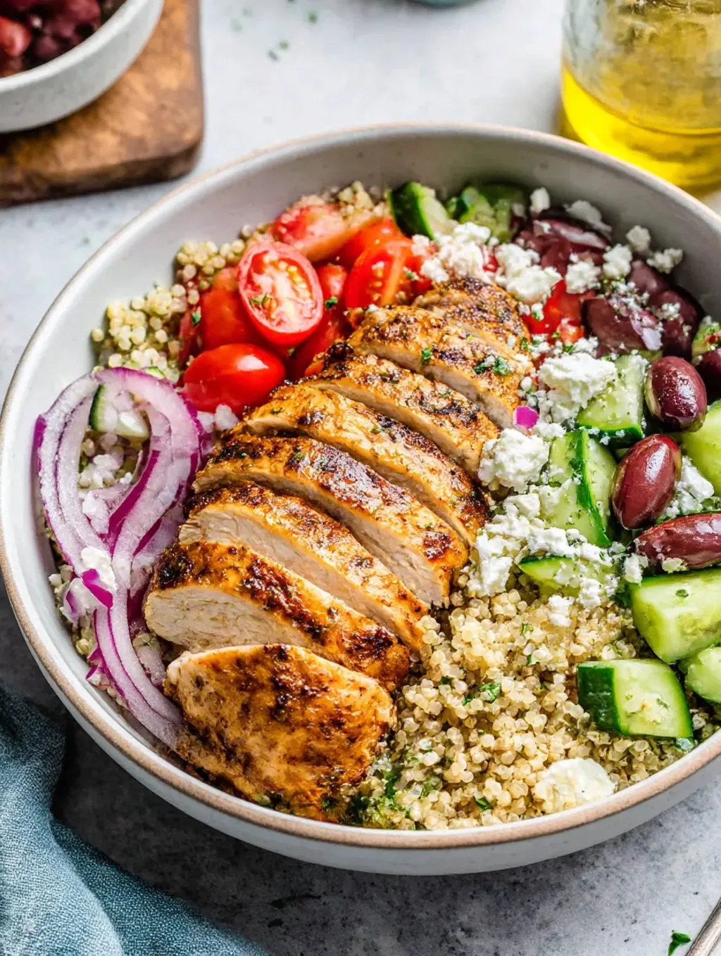 A Greek chicken quinoa bowl with vegetables.