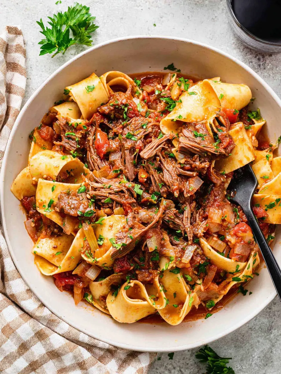 A bowl of pasta with meat and vegetables.