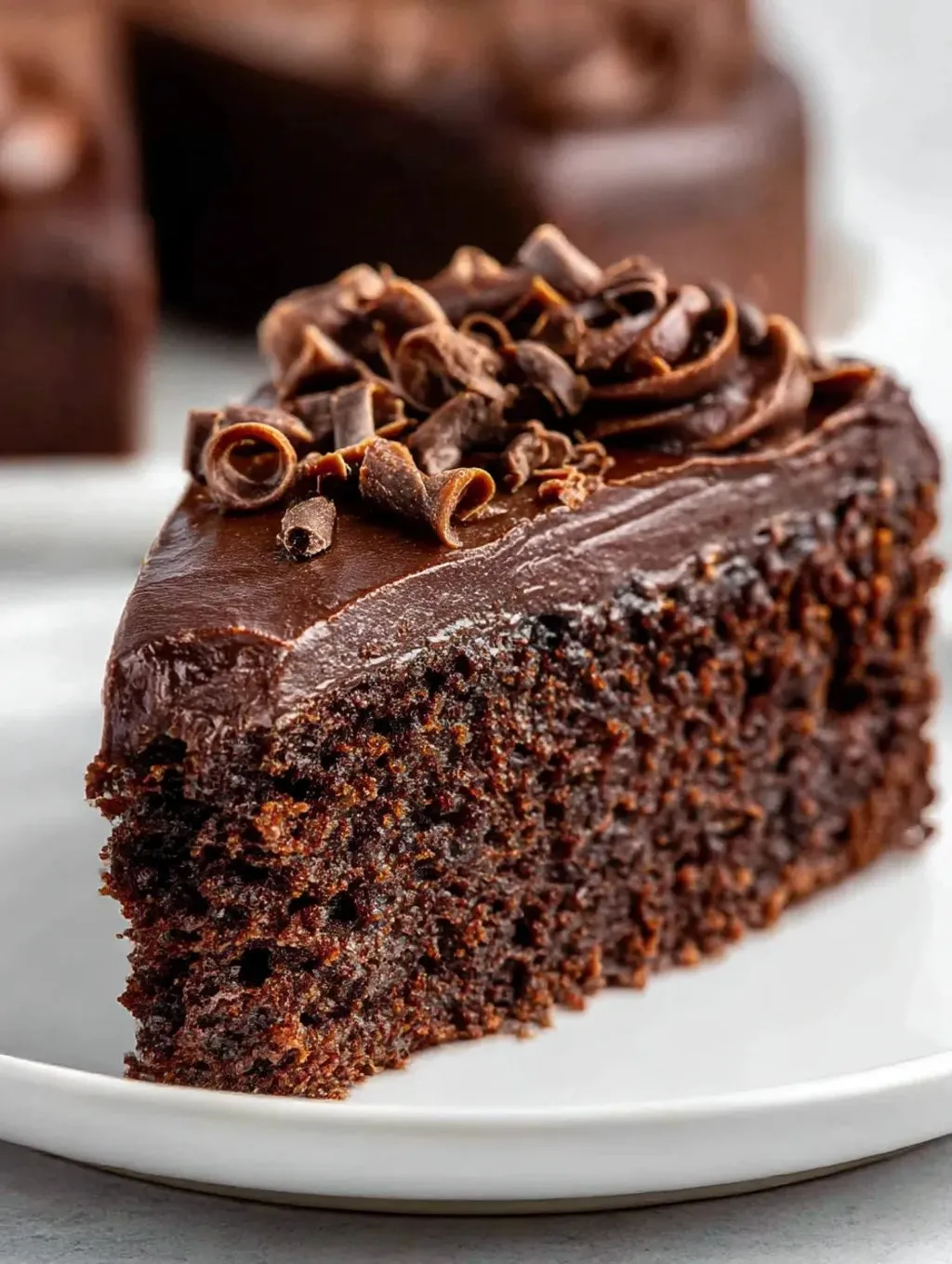 A slice of chocolate cake with chocolate chips on top.