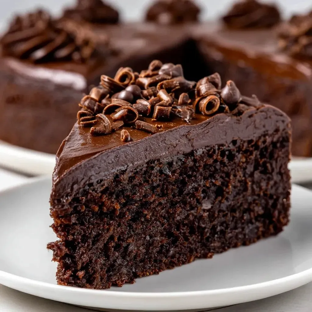 A slice of chocolate cake with chocolate chips on top.