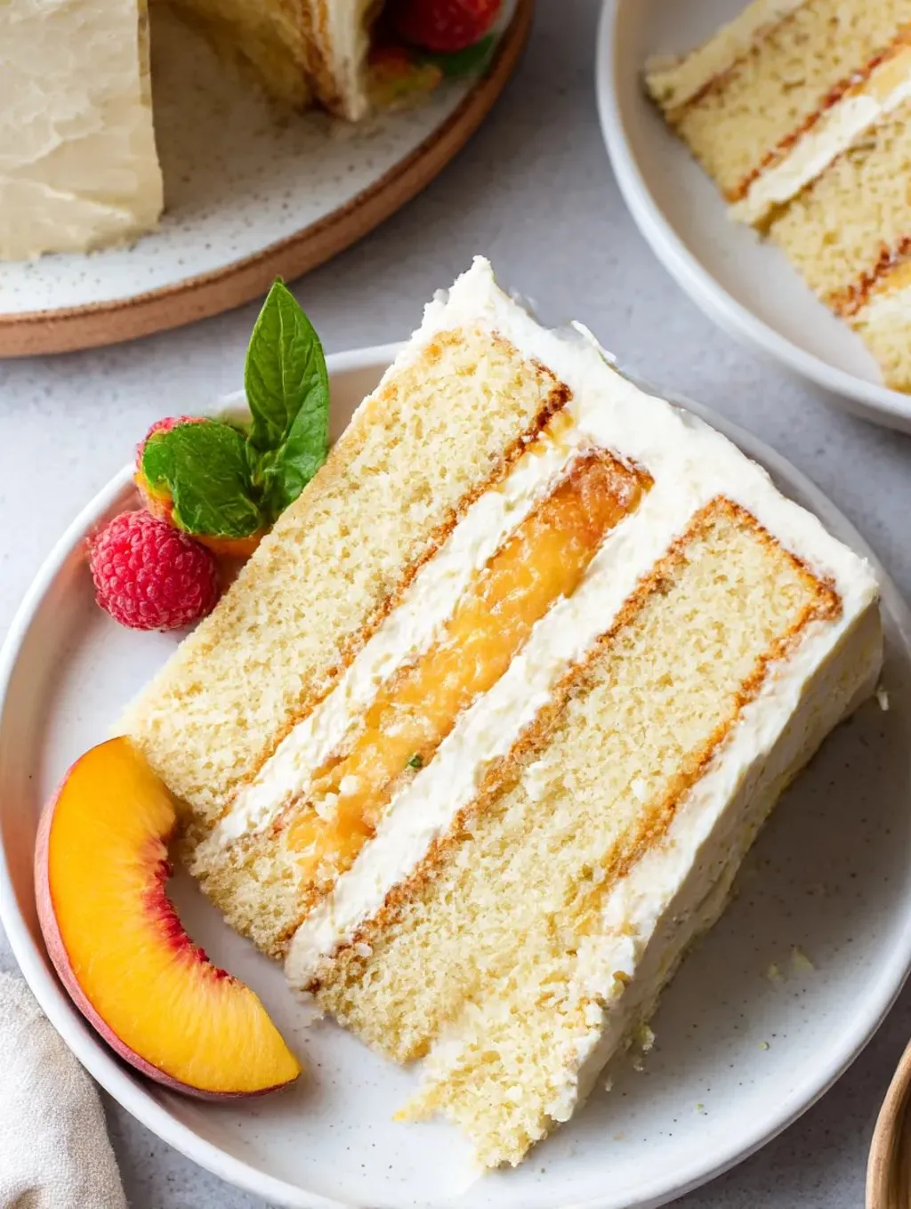 A slice of vanilla peach cake with marscapone frosting.