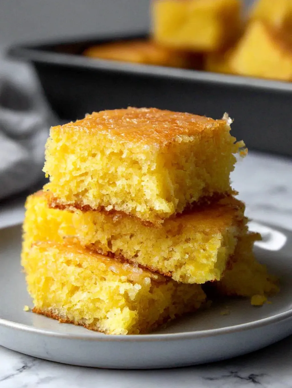 A stack of lemon cake slices on a plate.
