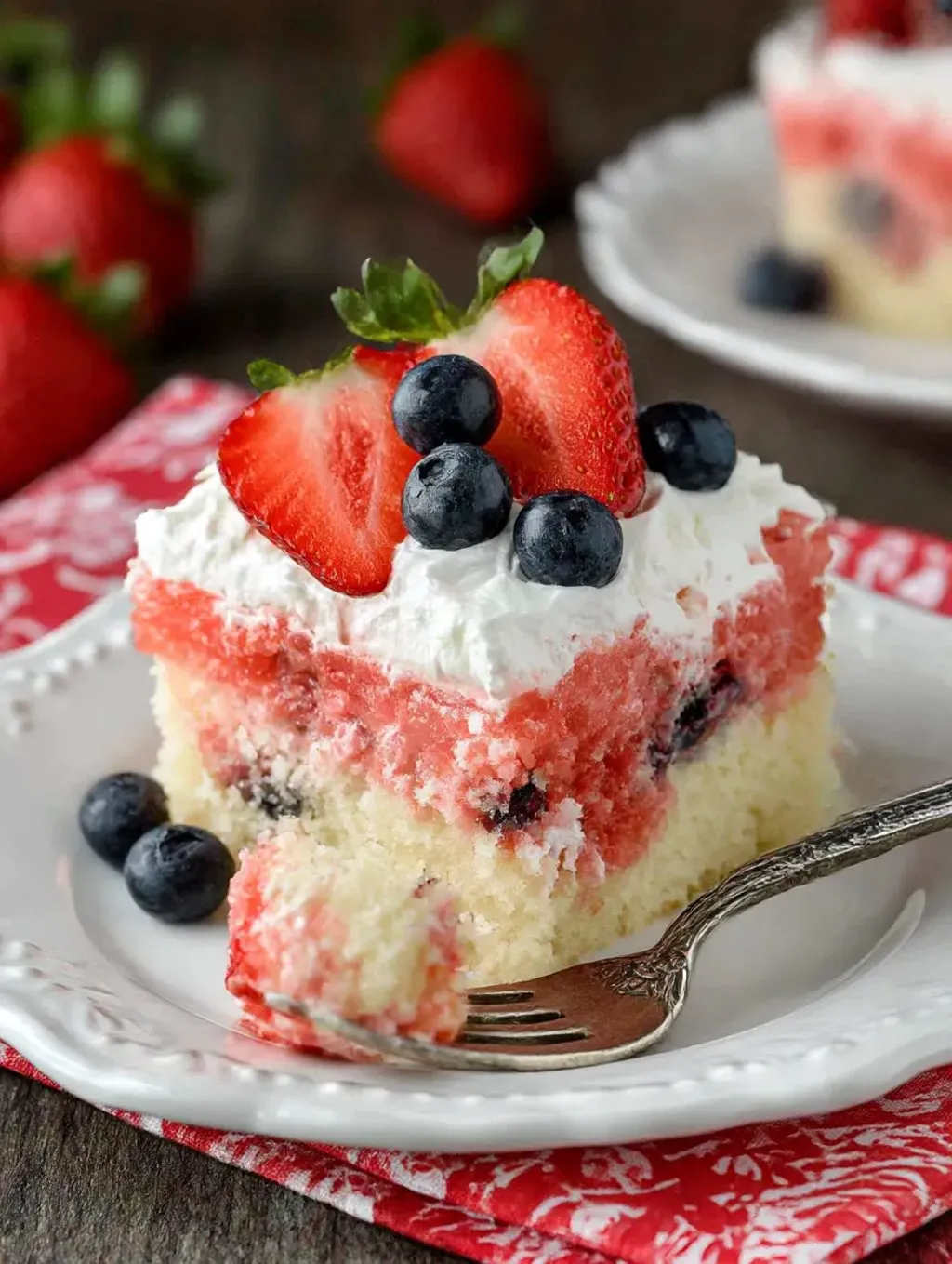 A slice of cake with strawberries and blueberries on top.