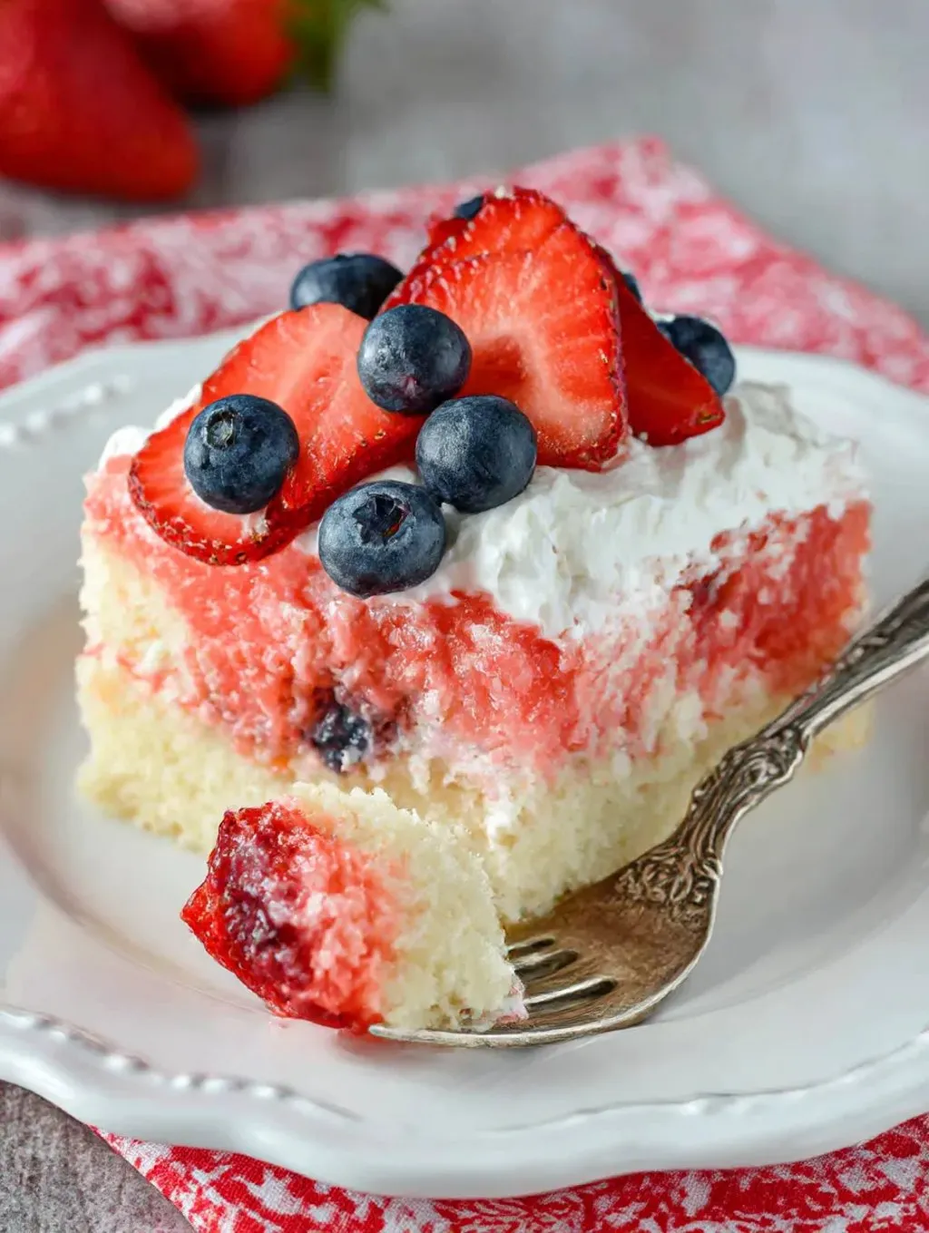 A slice of strawberry jello flag cake.