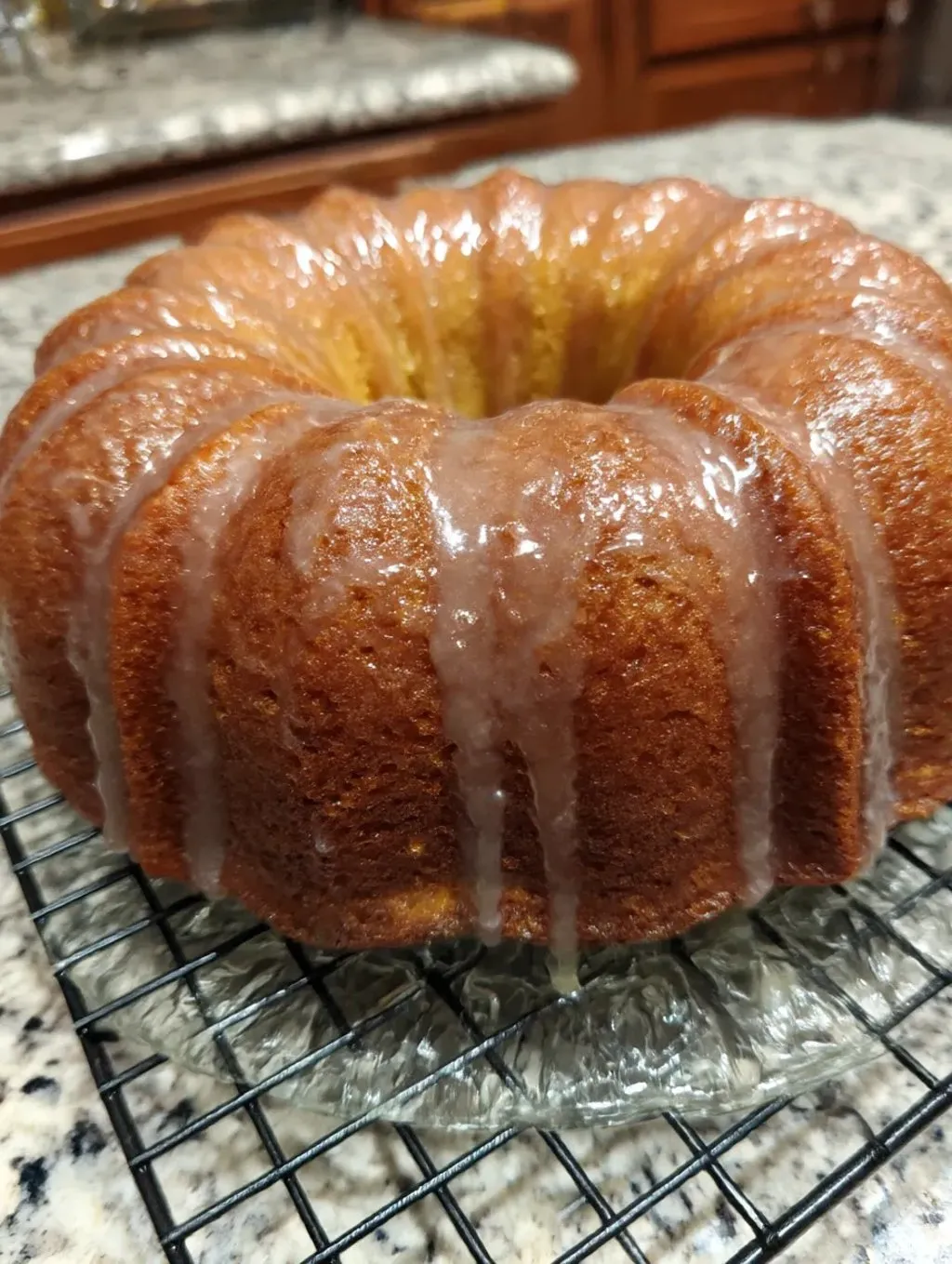 A buttermilk pound cake with glaze dripping off.