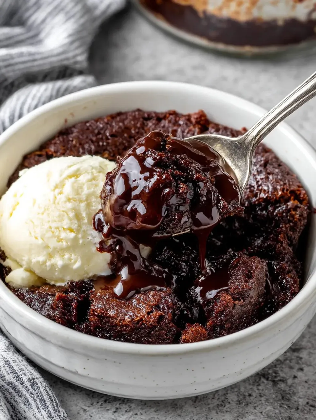 A bowl of chocolate cake with a scoop of ice cream on top.