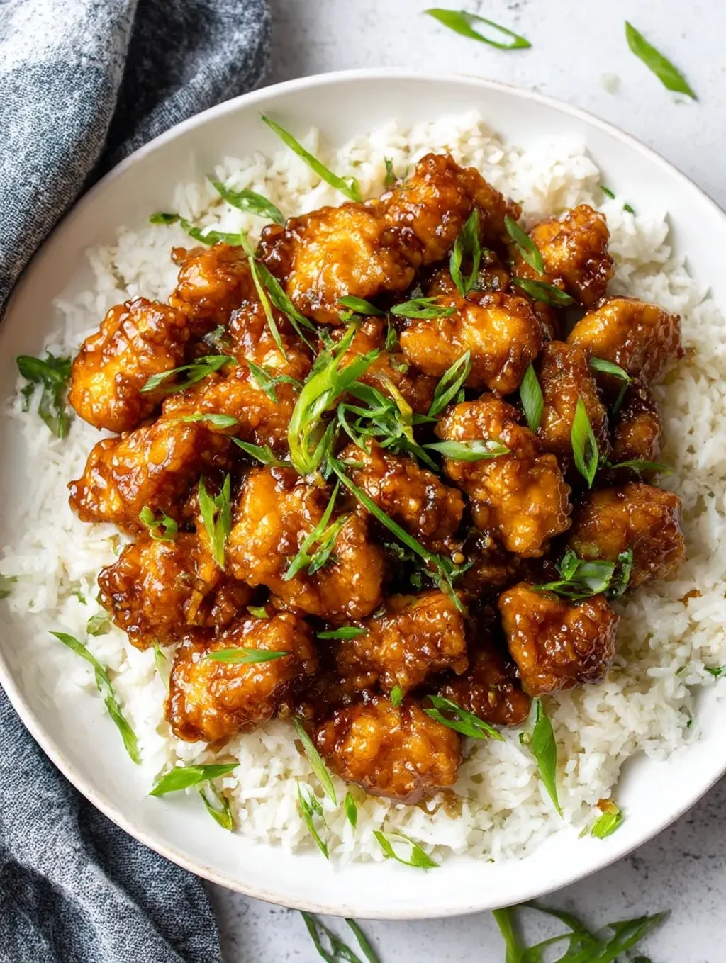 A plate of firecracker chicken with rice.