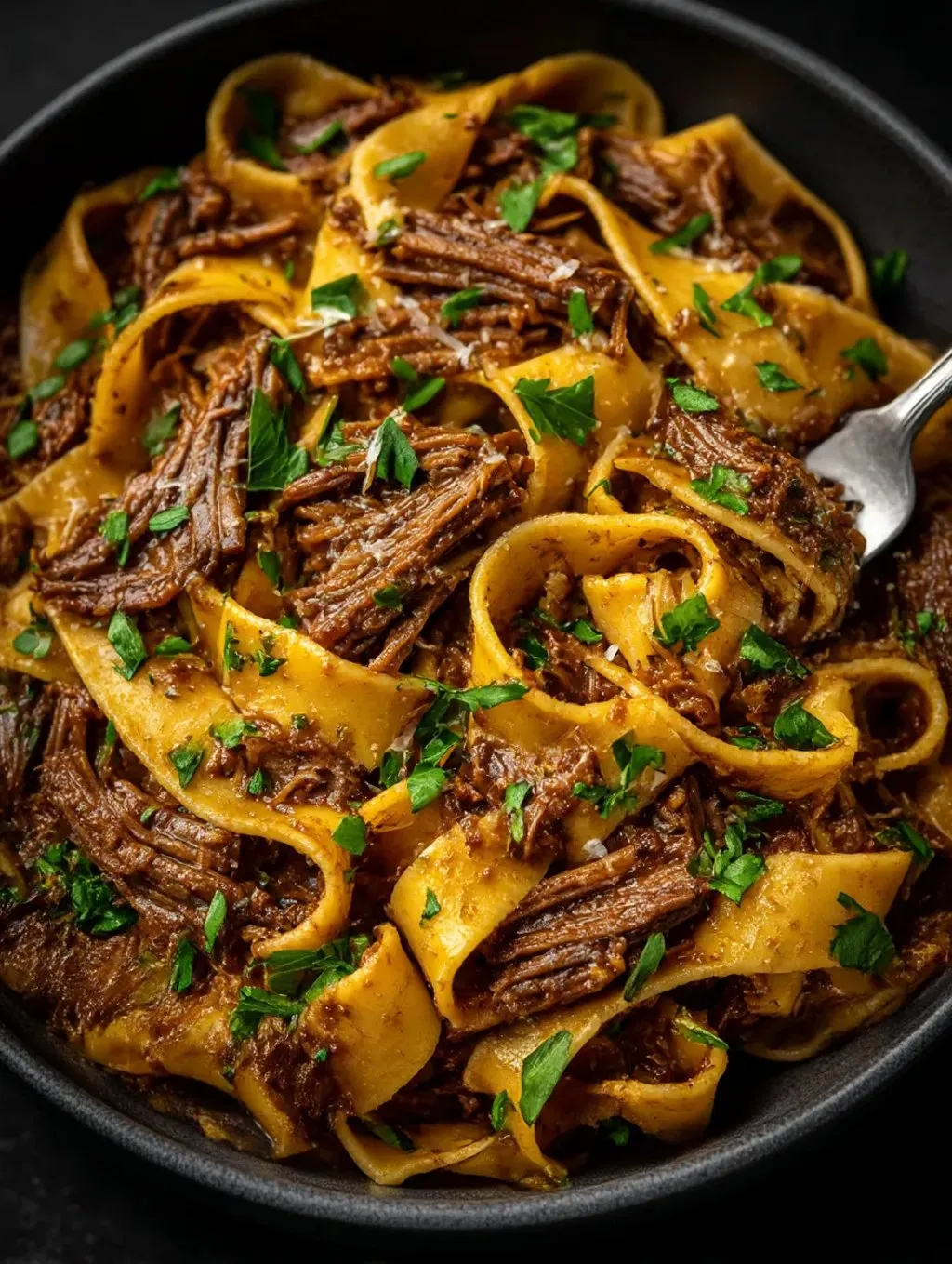 A bowl of short ribs in a tomato sauce.