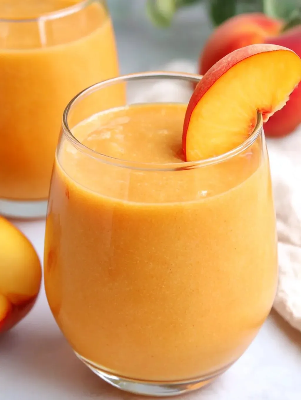 A glass of fresh peach blender juice.