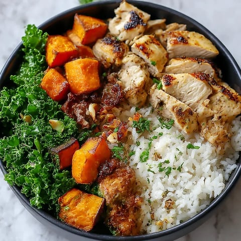 A bowl of food with rice, chicken, kale, and sweet potatoes.