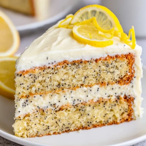 A slice of cake with lemon and yellow lemon wedges on top.