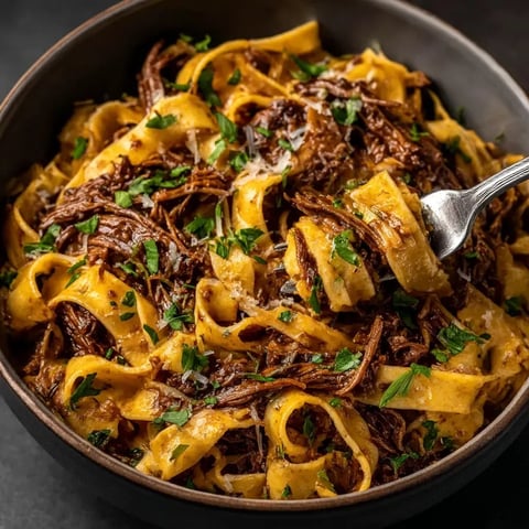 A bowl of pasta with meat and cheese.