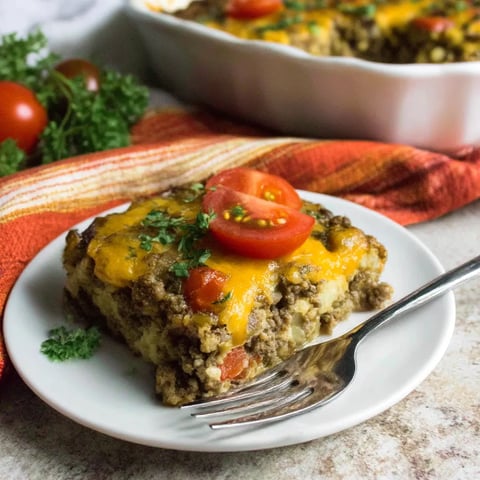 A white plate with a slice of casserole on it.